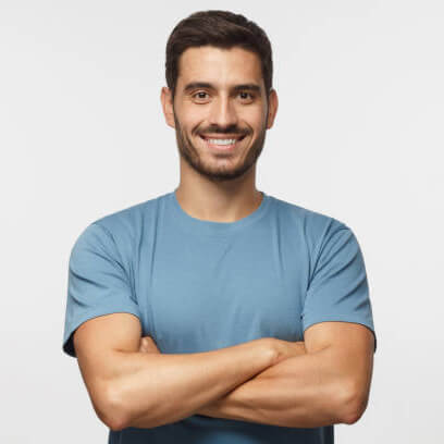 Portrait of smiling handsome man in blue t-shirt standing with crossed arms isolated on grey background